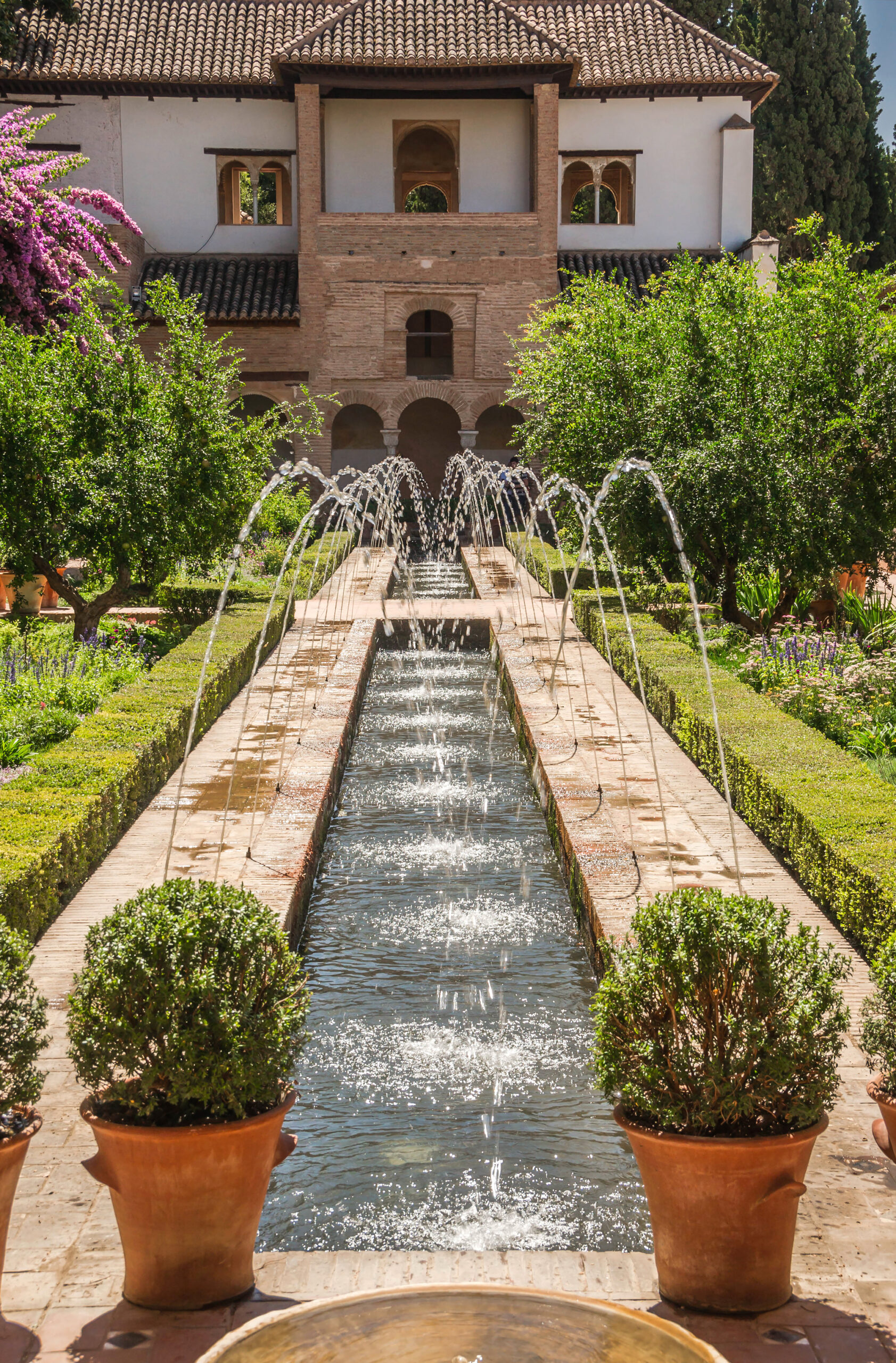 Patio de la Acequia in the Generalife gardens with water channels and planting beds.