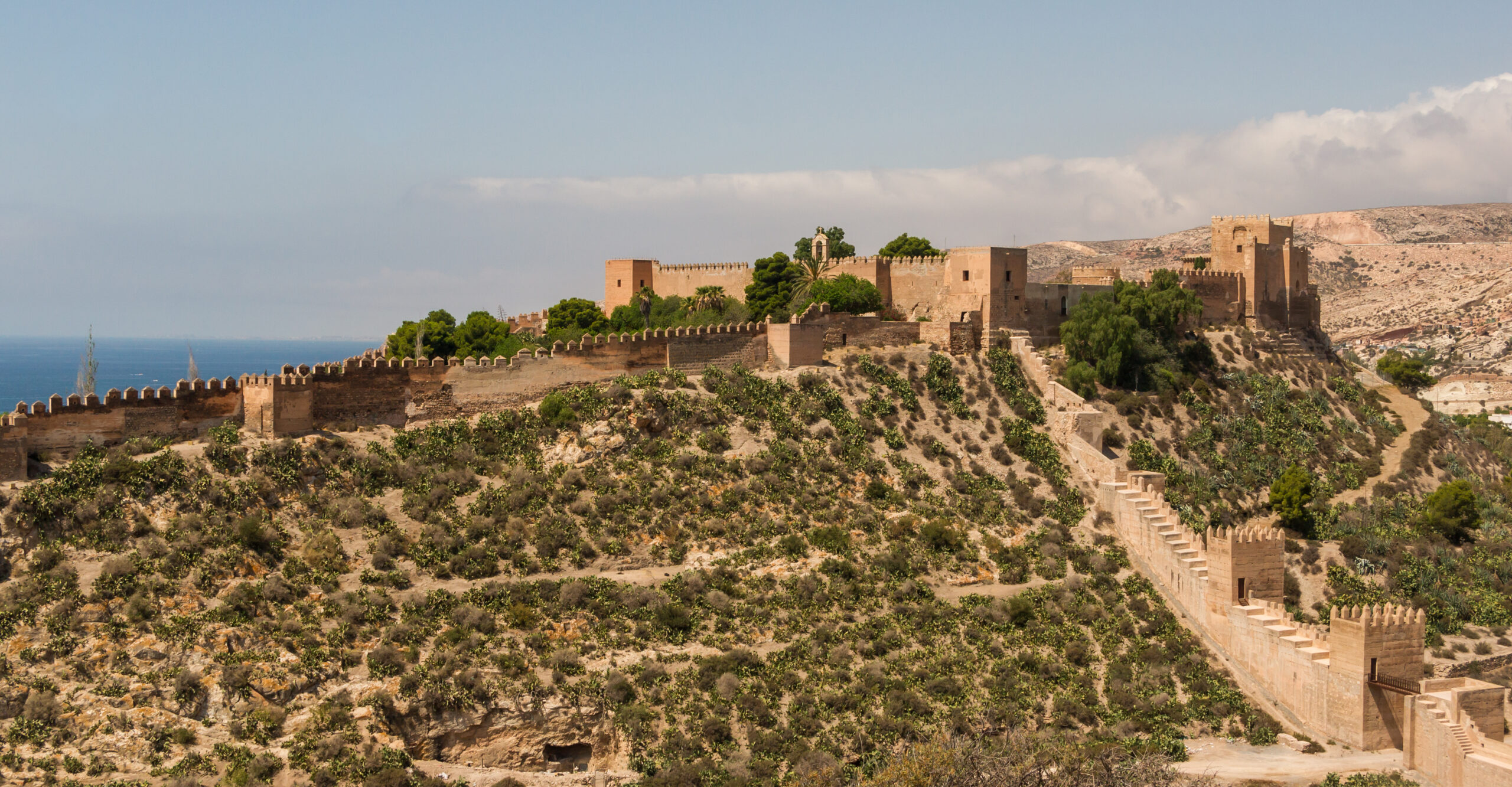 Outer walls and towers of the Alcazaba of Almeria under a clear sky.